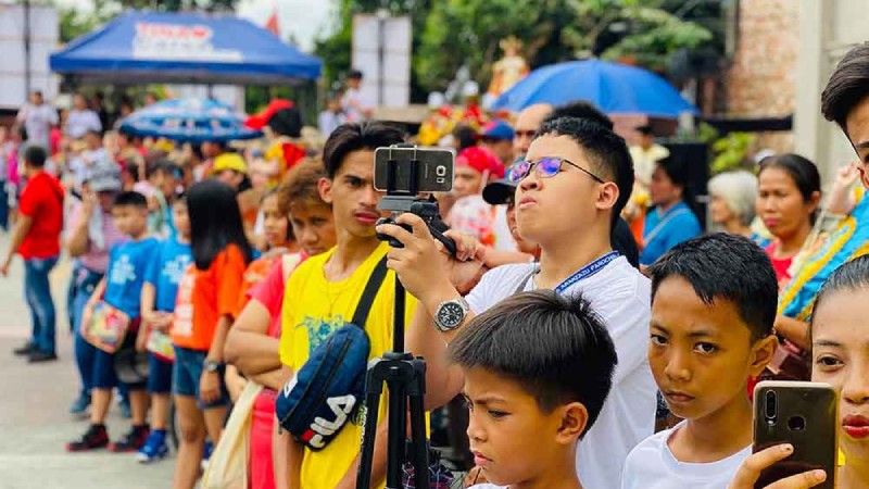 Man in a crowd using TVU Producer recording Santo Nino de Cebu parade