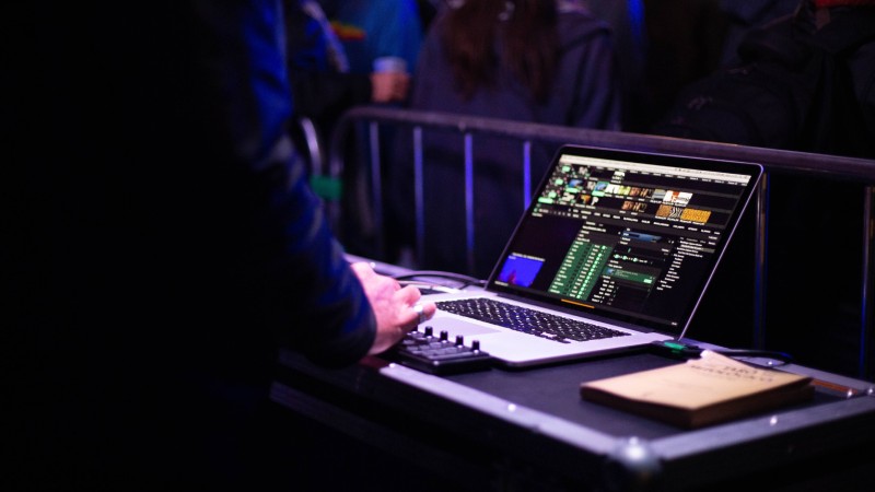 Man using a live production switcher on a laptop at an event